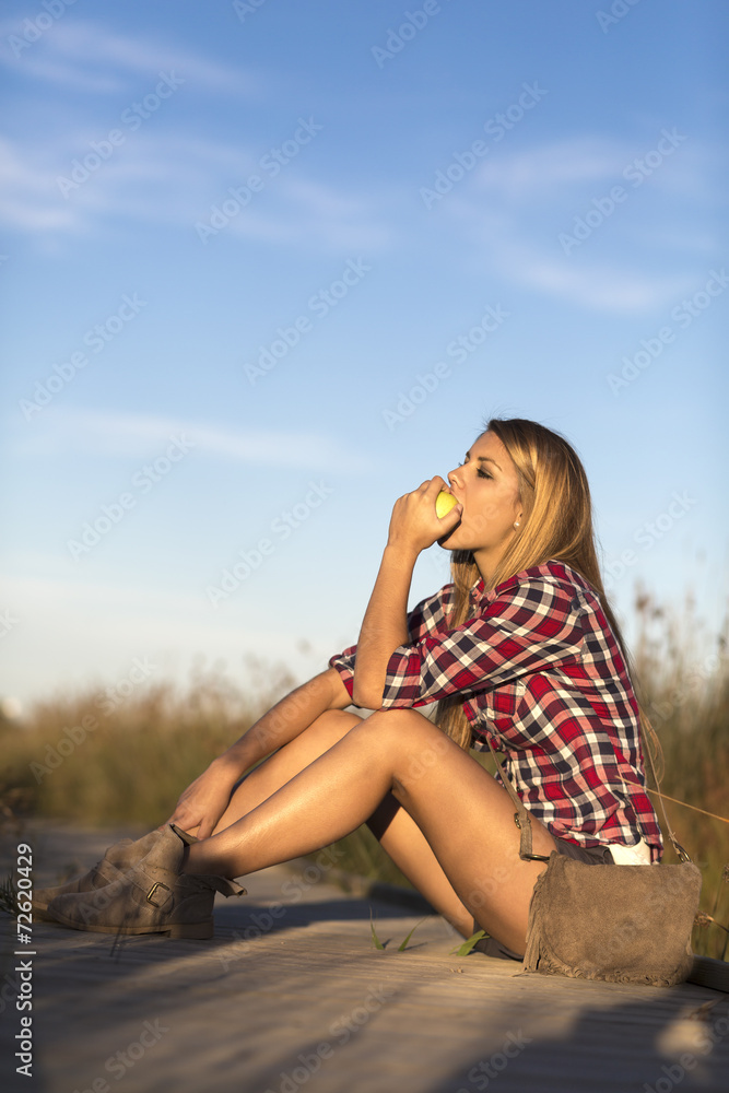 relaxing young woman eating an apple relaxing young woman eating an apple