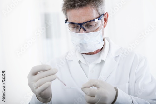 doctor working with microscope and blood