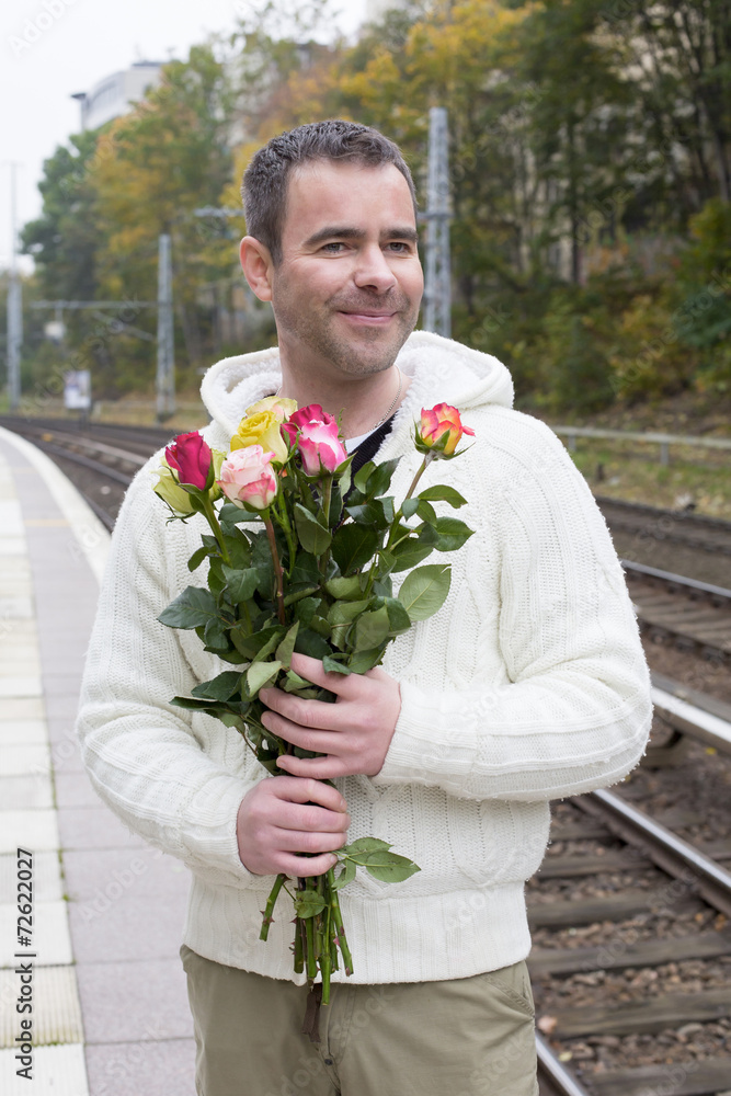 man waiting at train station with flowers man waiting at train station with flowers