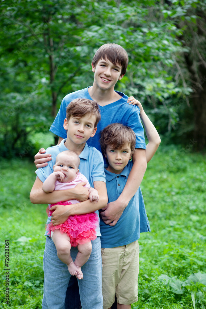 Portrait of three happy brothers and sisters