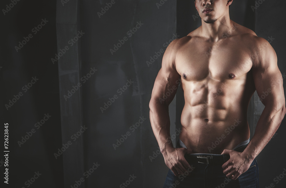 Close up of young muscular man lifting weights