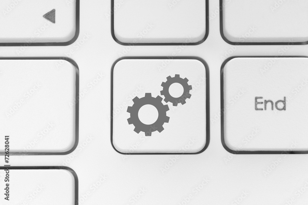 Cogwheels on white keyboard close-up. Cogwheels on white keyboard close-up.