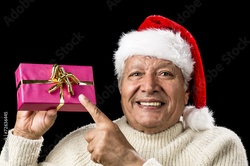 Joyous Old Man Pointing At Magenta Wrapped Gift photo