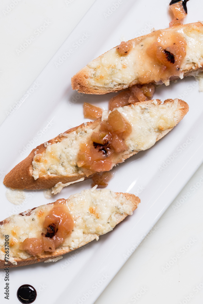 Toast bruschettes topped with cheese and quince jam Toast bruschettes topped with cheese and quince jam