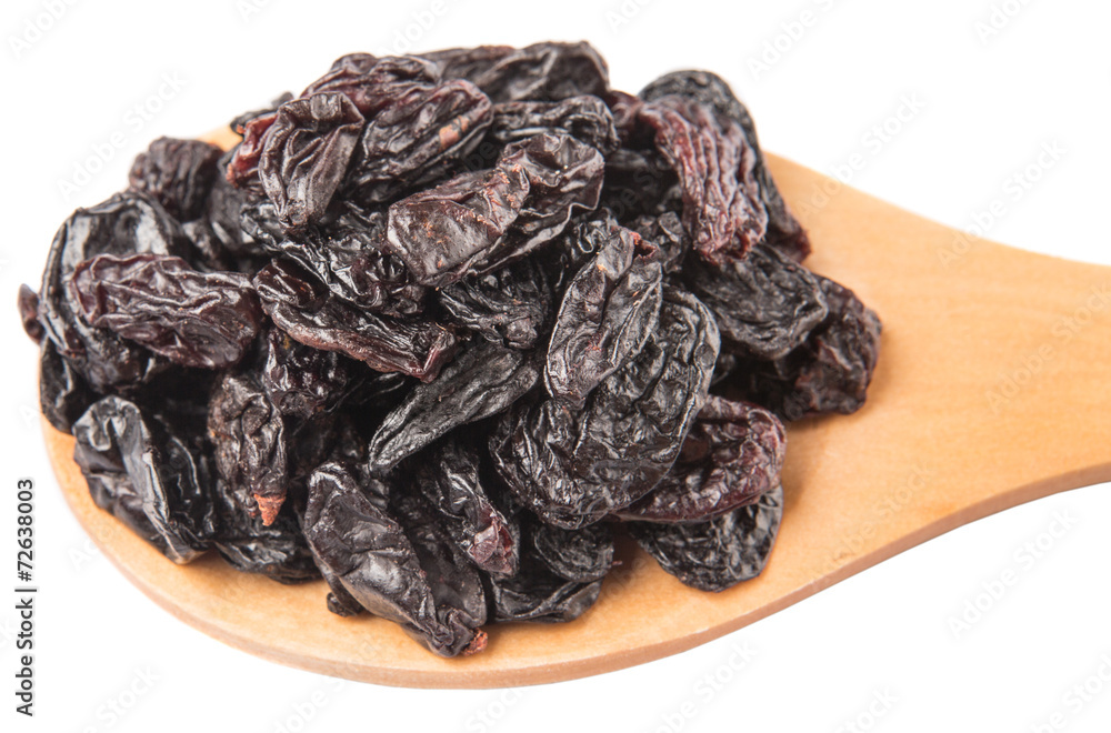 Black raisin on wooden spoon over white background Black raisin on wooden spoon over white background