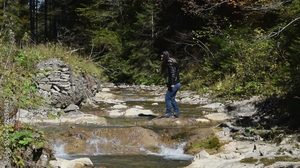 Brave girl crossing a river in a forest Brave girl crossing a river in a forest