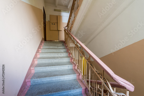 staircase with a handrail in the stairwell of an apartment house