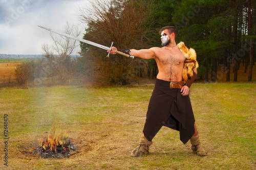 Portrait of a muscular ancient warrior with a sword