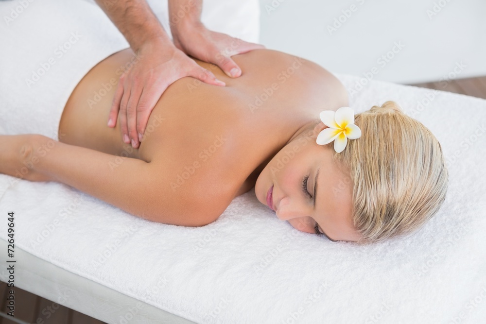 Woman receiving back massage at spa center Woman receiving back massage at spa center