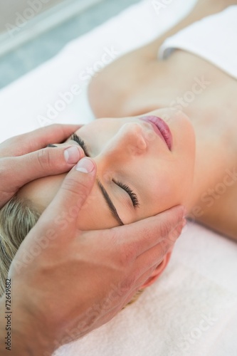 Attractive woman receiving head massage at spa center
