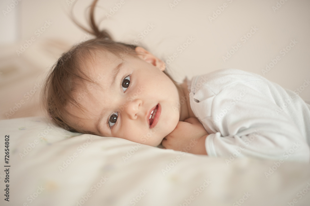 Cute little girl in pajamas on the bed in the morning Cute little girl in pajamas on the bed in the morning