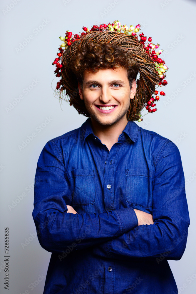 Portrait of a smiling man with arms folded and wreath