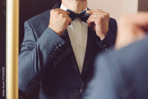 Groom with Bowtie before Mirror photo