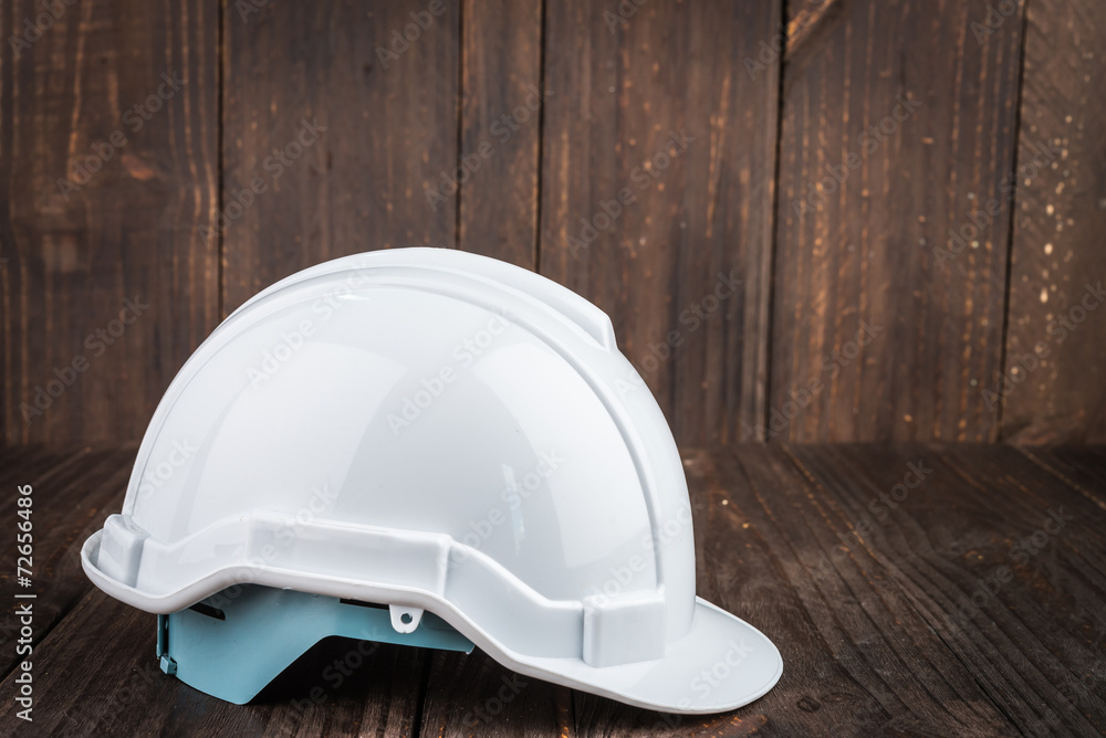 Construction hard hat on wooden background Construction hard hat on wooden background