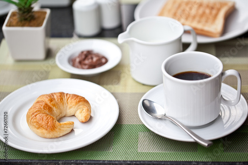 Hotel breakfast. croissant and coffee with milk
