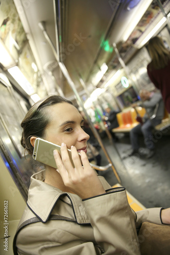 Businesswoman in subway using smartphone