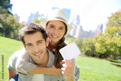 Cheerful couple holding tourits pass of New York City photo