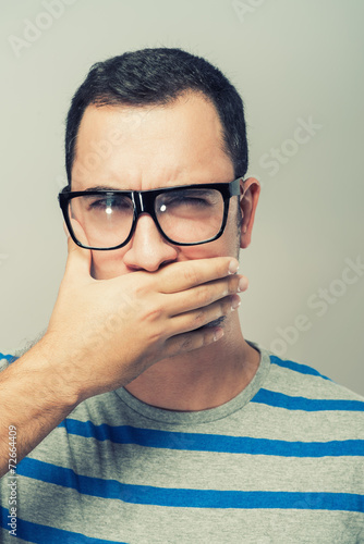 Young man in glasses covered her mouth