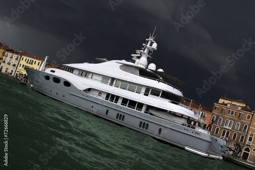 Yacht in front of typical Venetian houses with arched windows