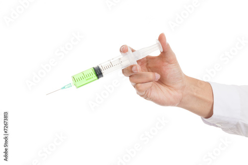 Close up of syringe with green medicine in hand