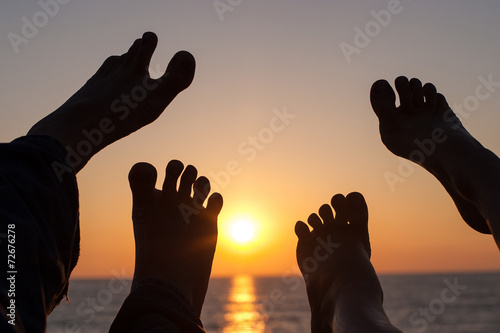 Canvas Print A couple wiggle their 4 happy feet on the beach at sunset