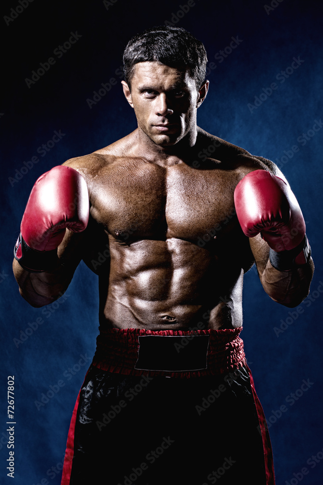 Portrait of boxer posing in studio in gloves Portrait of boxer posing in studio in gloves