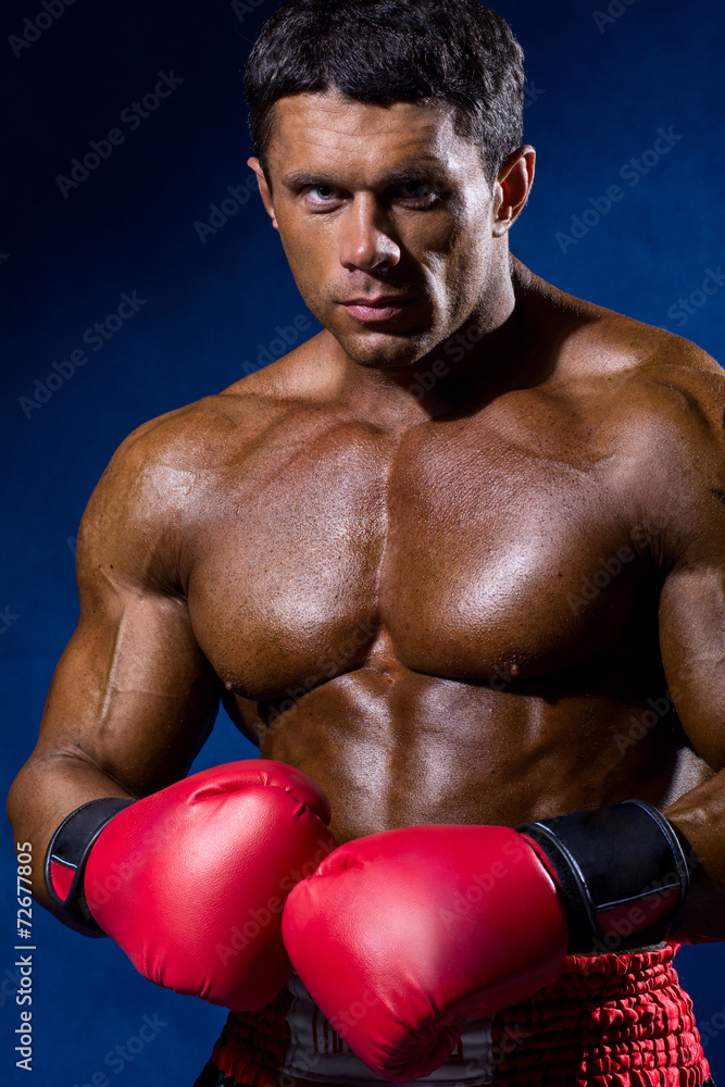 Portrait of boxer posing in studio in gloves