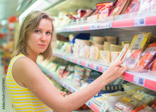 Young woman choosing meat in grocery store.