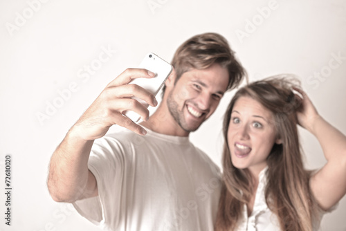 Young couple with smart phone taking selfie