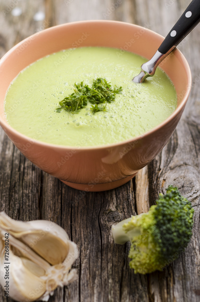 Brokkolicremesuppe in antiker Porzellanschale auf Holztisch Brokkolicremesuppe in antiker Porzellanschale auf Holztisch