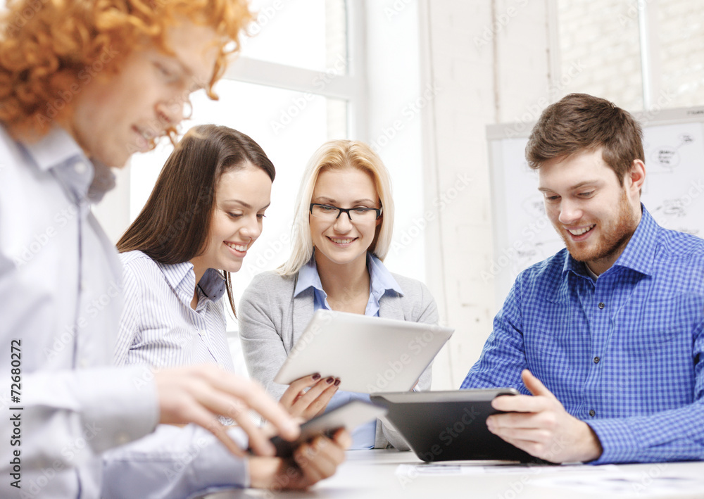 smiling team with table pc and papers working smiling team with table pc and papers working