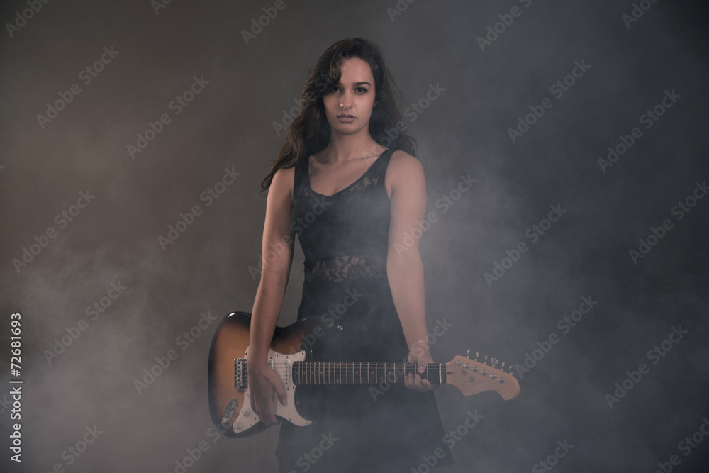 Teenage rock girl with electric guitar. Wearing black dress. Teenage rock girl with electric guitar. Wearing black dress.