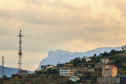 Radio tower and a building in the mountains at sunset
