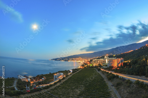View of the city and vineyard at night with lights clouds