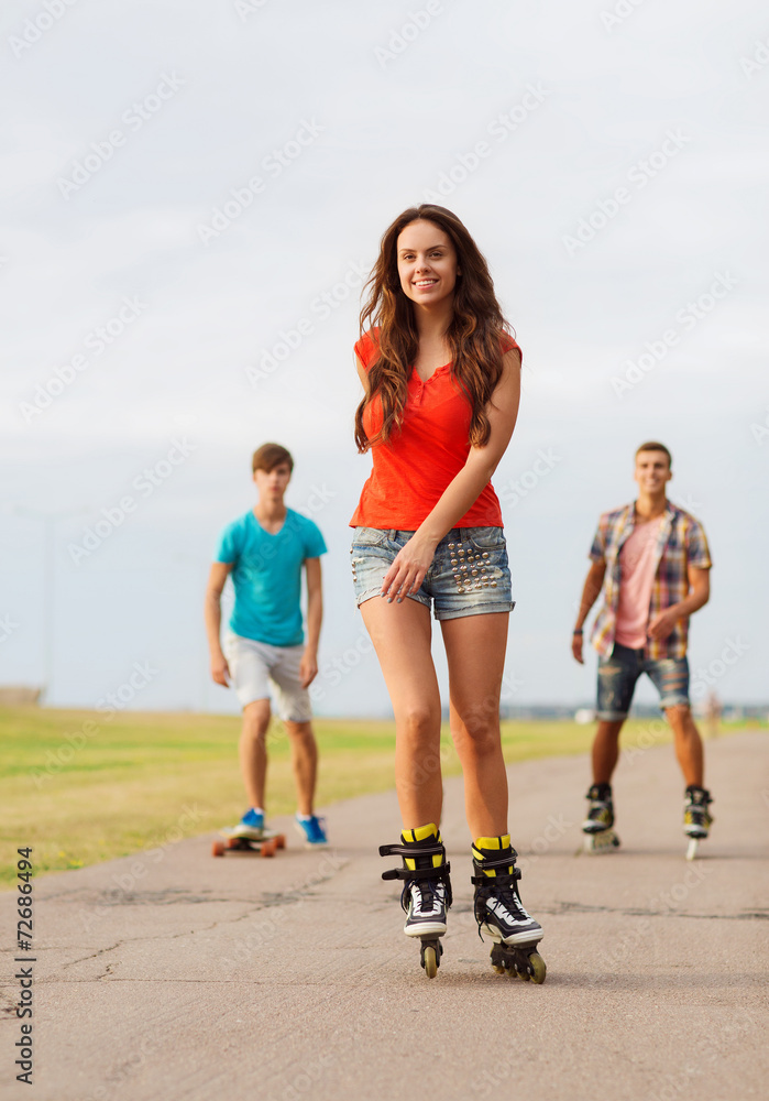 Obraz premium group of smiling teenagers with roller-skates