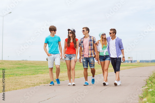 group of smiling teenagers walking outdoors