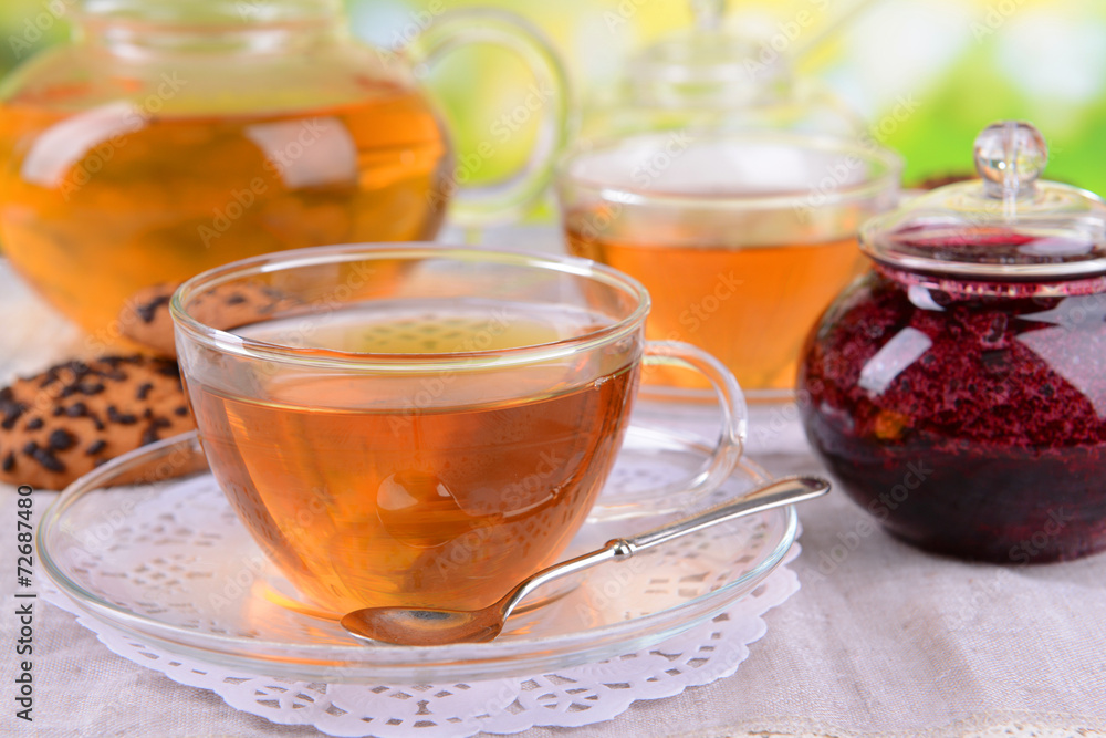 Teapot and cups of tea on table on bright background Teapot and cups of tea on table on bright background