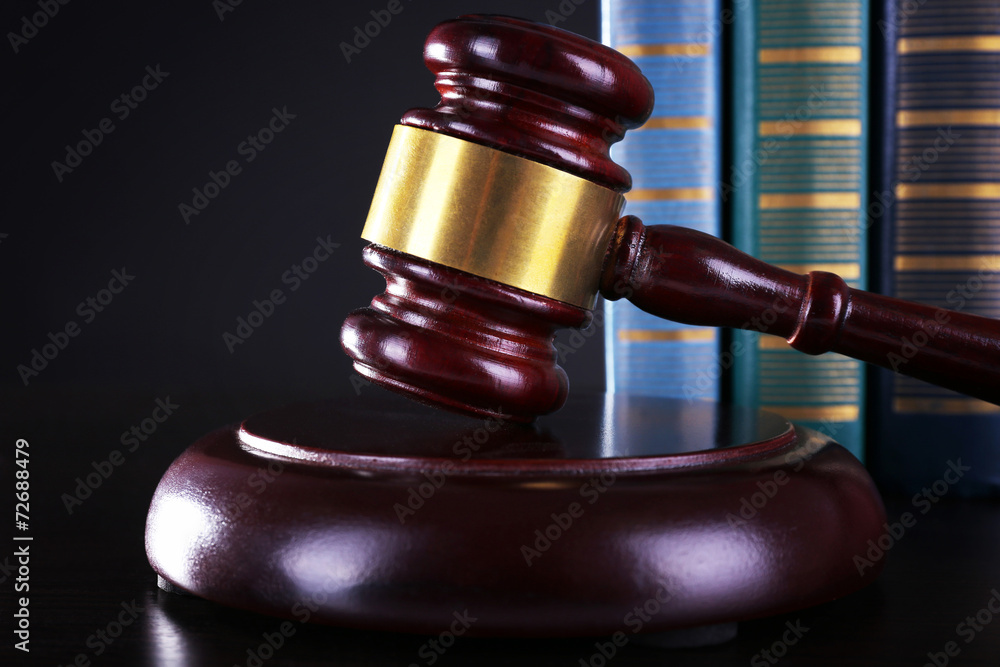 Judge's gavel and books on dark grey background Judge's gavel and books on dark grey background