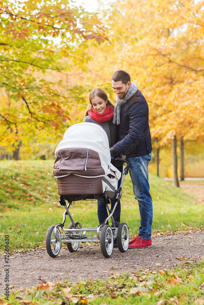 smiling couple with baby pram in autumn park smiling couple with baby pram in autumn park