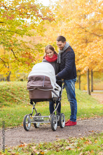 smiling couple with baby pram in autumn park © Syda Productions