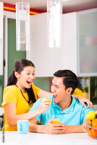 Asian woman feeding boyfriend with apple