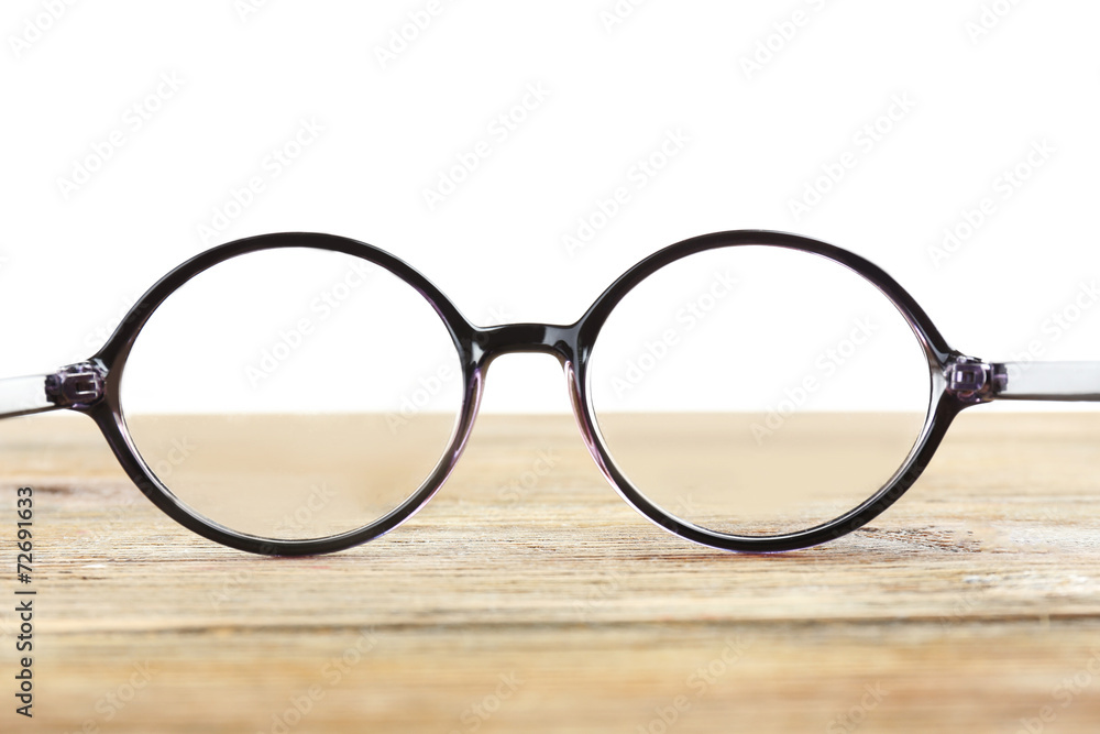 Eye glasses on wooden table on white background Eye glasses on wooden table on white background