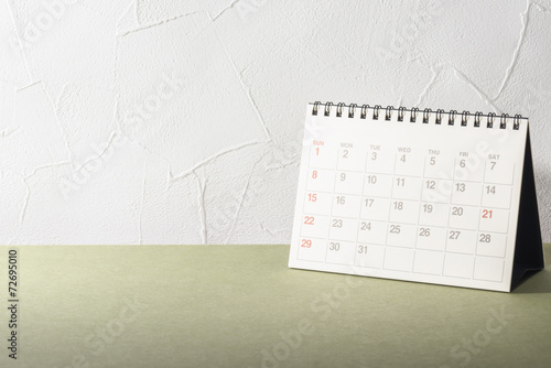 Desk.Calendar on Desk.Empty Wall of Stucco.