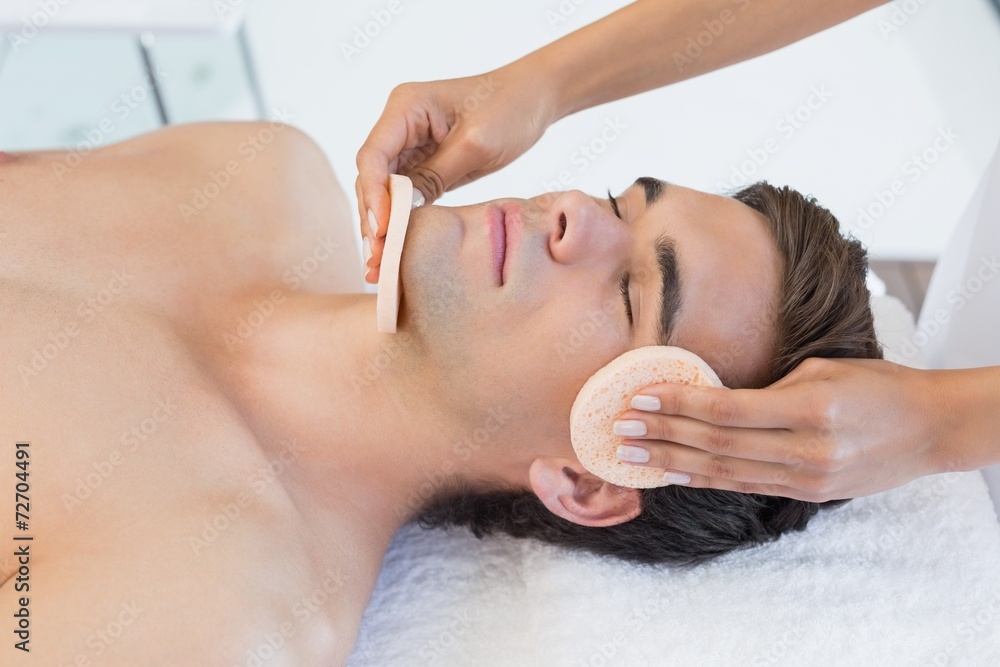 Fototapeta premium Man receiving facial massage at spa center