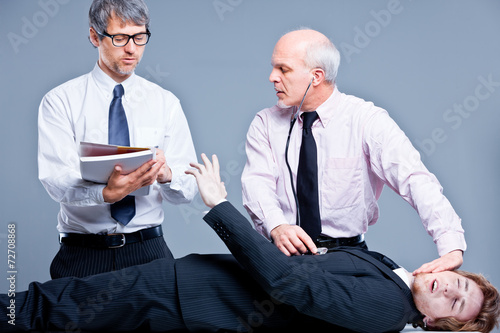 clerks repairing a businessman for fun photo