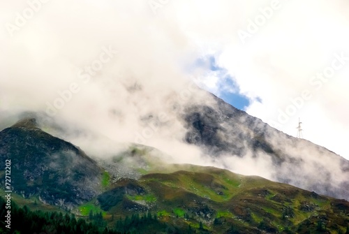 View over a mountain peak with clouds.