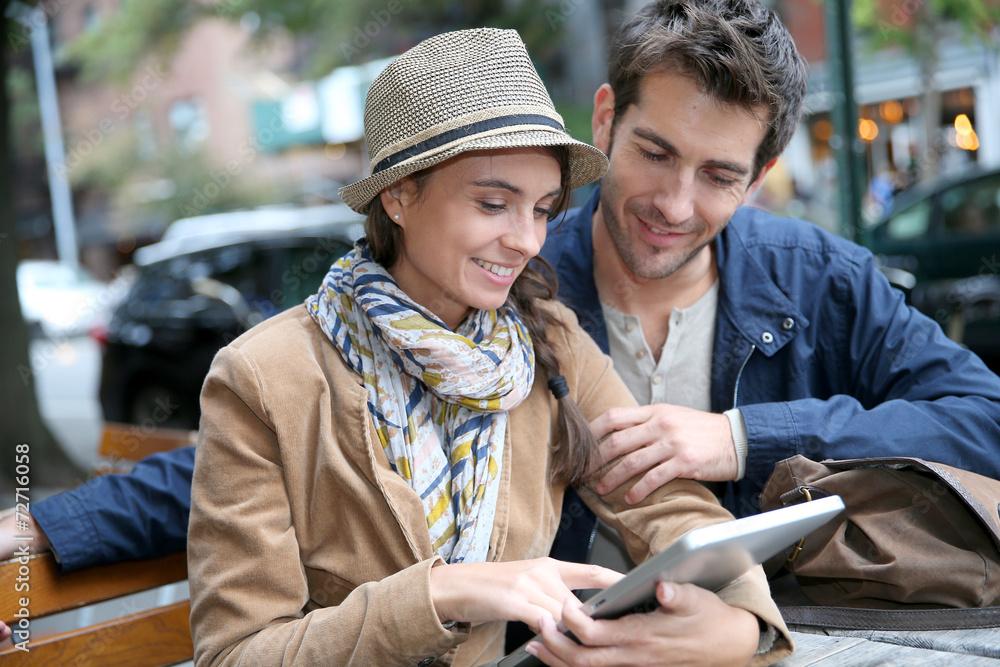 Couple in town sitting in coffee shop and using digital tablet Couple in town sitting in coffee shop and using digital tablet