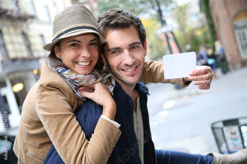 Cheerful couple showing New York City pass