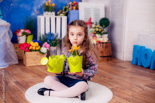 happy little girl. watering the flowers in the pot. Mother's Day