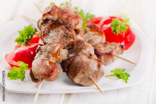 Kebabs served with vegetables on  white plate